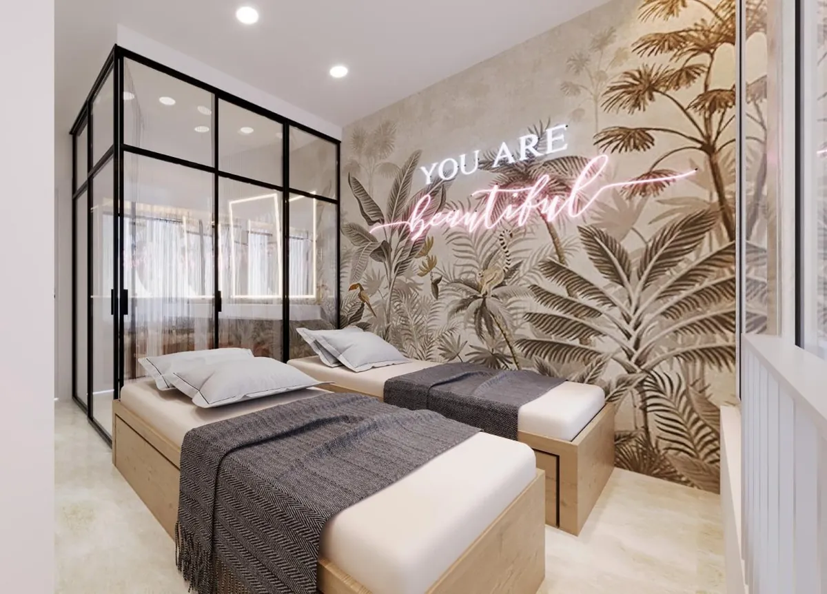Guest room with twin oak beds, tropical wall mural and a black-framed glass partition